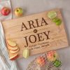 Maple wood cutting board with engraved names and address on it.