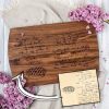 A personalized wood recipe cutting board with a handwritten note on it.