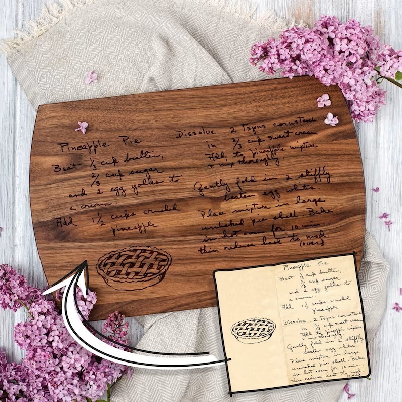 A personalized wood recipe cutting board with a handwritten note on it.