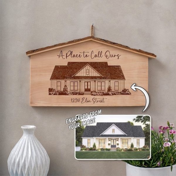 A wooden sign with an image of a house and a potted plant.