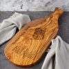 A wooden cutting board with a picture on it.