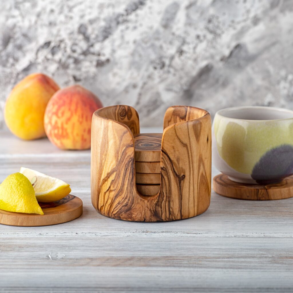 A wooden coaster set with lemons and a cup of coffee.