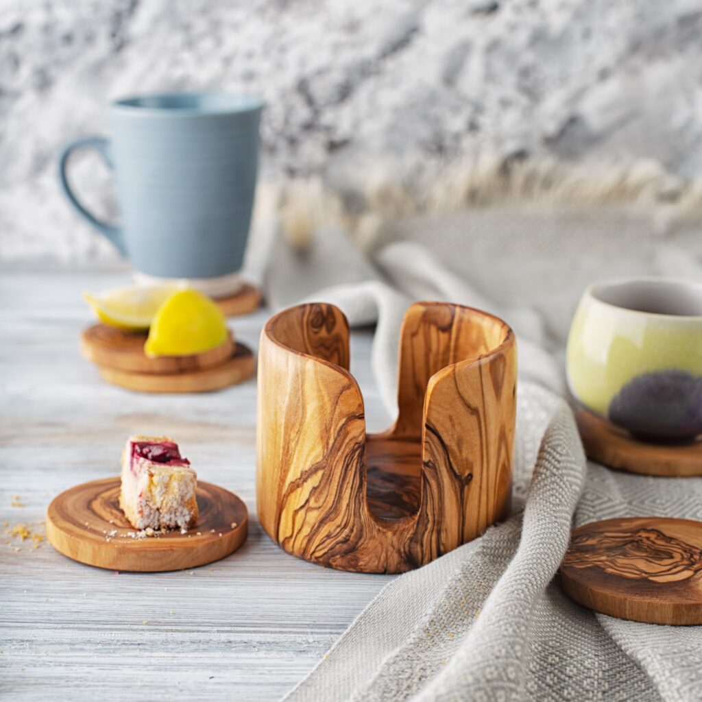 A wooden coaster with a cup of coffee and a slice of lemon.