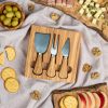 A wooden cheese board with cheese, crackers and olives.