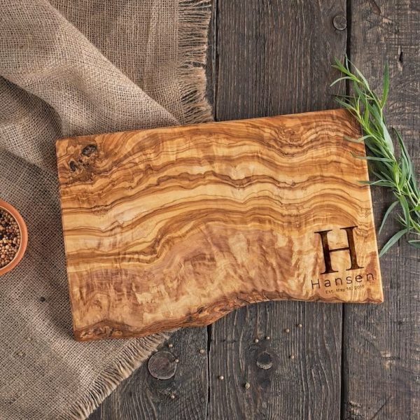 Olive wood cutting board with monogram engraved in the lower right corner.