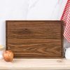 A wooden cutting board with an apple on it.