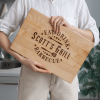 A woman holding a Grilling Gift Cutting Board that says Scott's grill.
