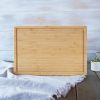 Empty bamboo cutting board on a kitchen countertop.