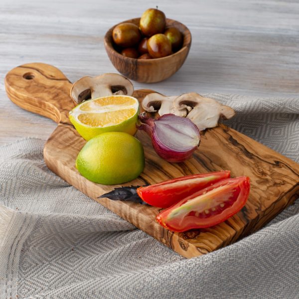 A Olive Wood Paddle Board with vegetables on it.