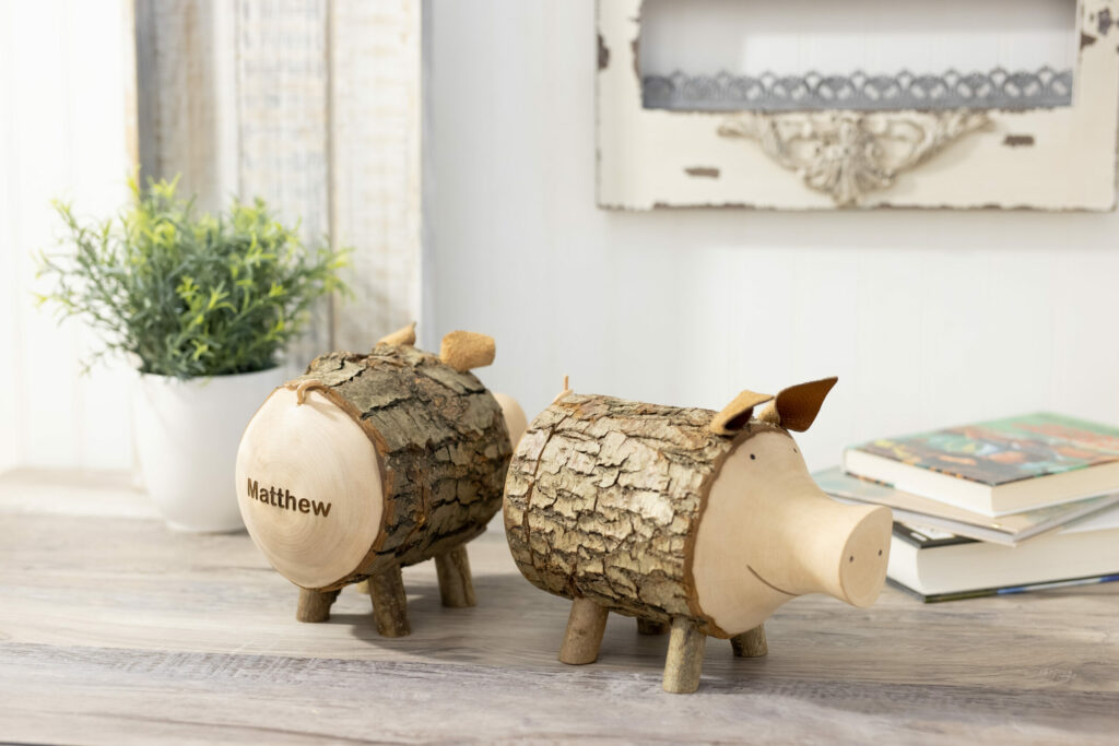 Two wooden Piggy Banks sitting on a wooden table.