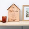 A wooden house with a candle next to it.