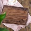 A walnut cutting board with a flower on it.