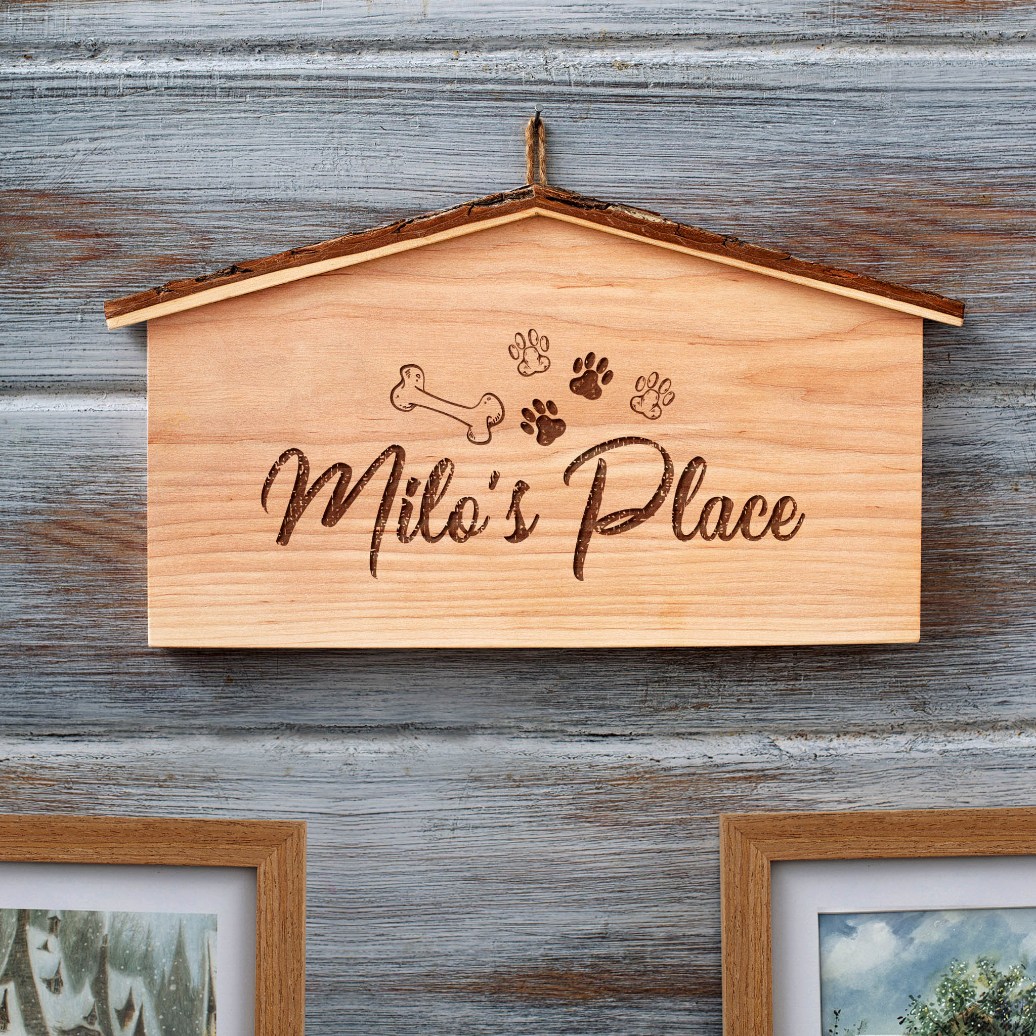 A wooden dog house with paw prints on it.