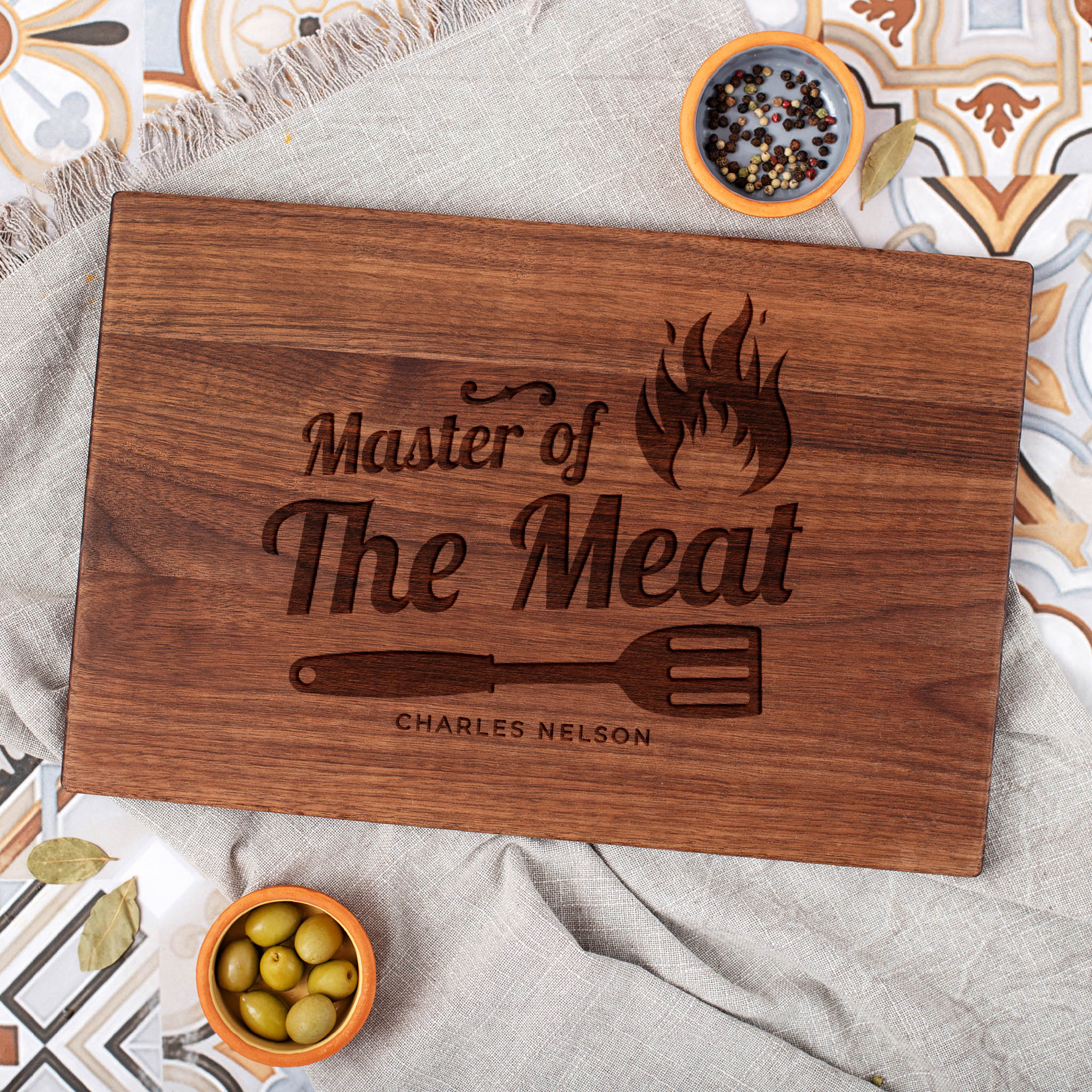 A wooden cutting board with the words master of the meat.