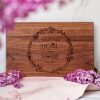 A wooden cutting board with the words home is where the heart is.