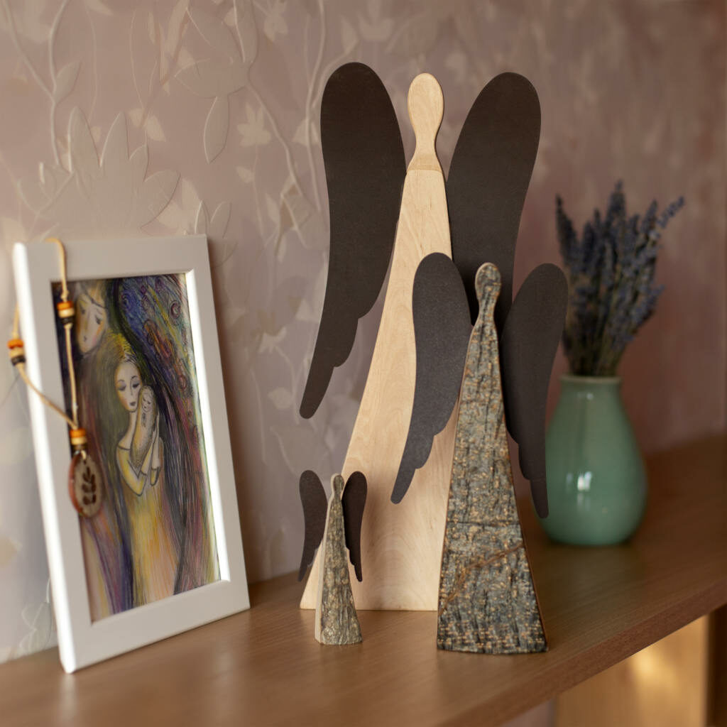 A shelf with angel figurines and a painting on it.