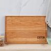 A wooden cutting board with a logo on it.