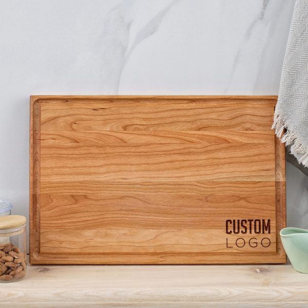 A wooden cutting board with a logo on it.