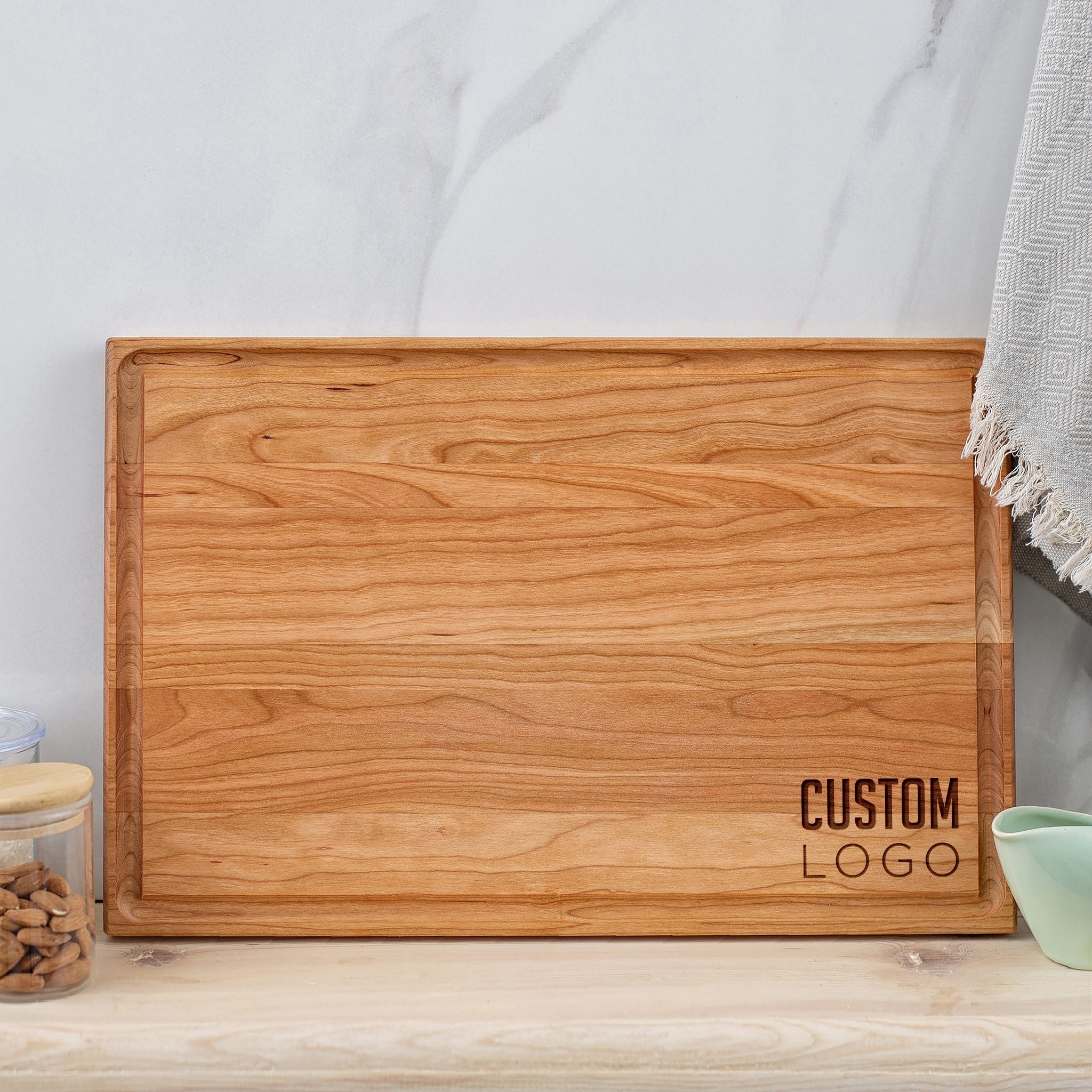 A wooden cutting board with a logo on it.
