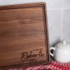 Custom walnut cutting board with personalized name.