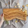 A person holding a custom logo cutting board.