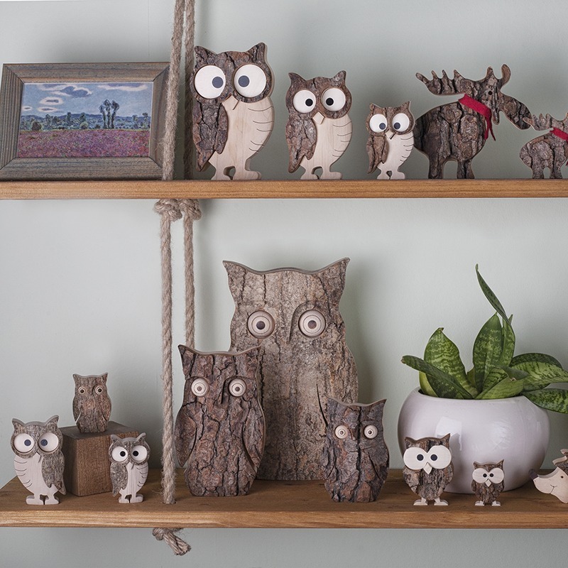 A shelf with wooden owl figurines on it.